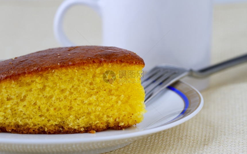 甜的美味糕点紧贴着一块橙色蛋糕在白盘子上图片