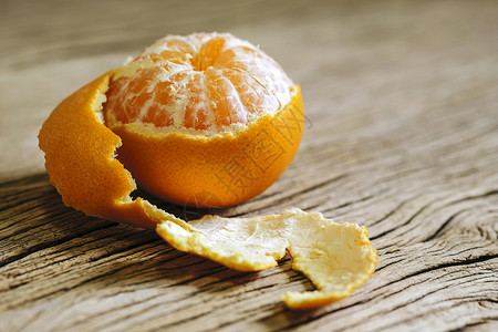 墙纸甜的橘子在木背景上剥了一半饮食图片
