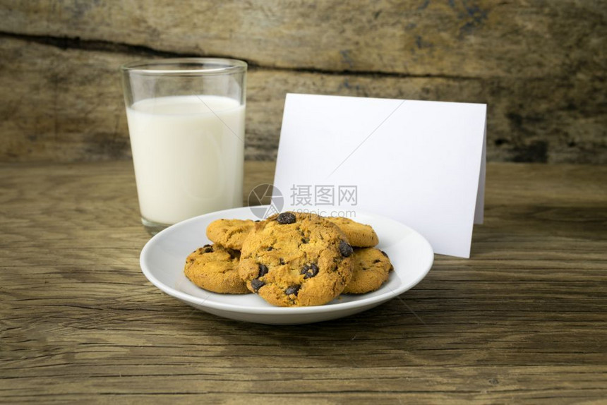 食物饼干和一杯加牛奶的子带有圣塔白纸条笔记前夕图片