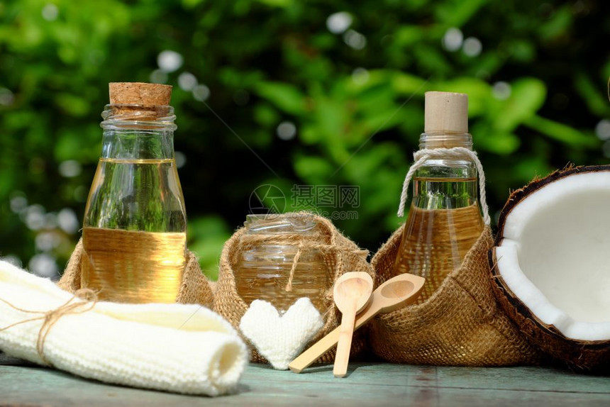 木制的治疗瓶子天然化妆品产绿底玻璃罐中的椰子油用于皮肤护理的必要油丰富维他命有机化妆品以及温泉按摩机的油图片