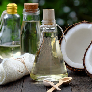 绿椰子美丽的关心天然化妆品产绿底玻璃罐中的椰子油用于皮肤护理的必要油丰富维他命有机化妆品以及温泉按摩机的油为了背景