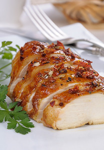 一种烤鸡胸在盘子上切片烘烤的低卡路里图片