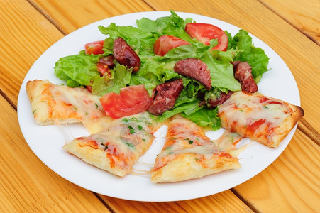 番茄莴苣配有融化奶酪和新鲜蔬菜沙拉的披萨片和脆皮图片