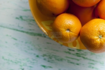 多汁的黄色盘子上橙橘柳木背景老成熟图片