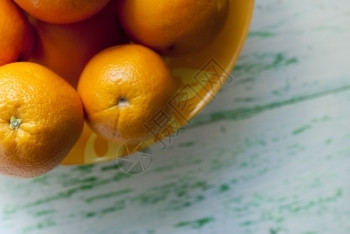 有机的老黄色盘子上橙橘柳木背景黄色图片