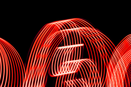 来自黑色背景上的灯条亮红色螺旋图案来自黑色背景上的灯条明亮螺旋图案模式时间抽象的背景图片