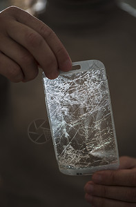 手握破碎的智能光谱屏幕背真保持智能手机损坏的图片