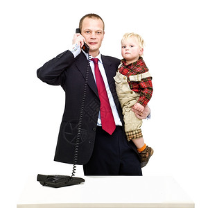 职业正式的白种人一个在电话上工作的父亲在照顾他的幼儿子时图片