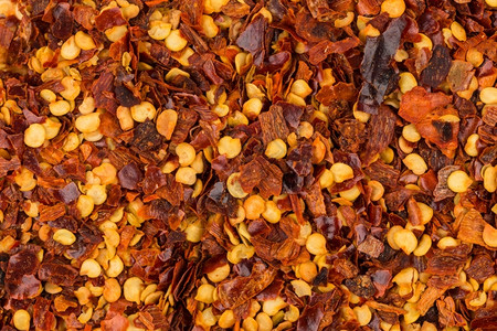 地面寒冷干燥一堆粉碎的红辣椒干片和种子作为背景图片