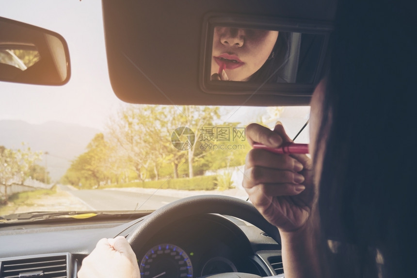 镜子斯林拉特多任务处理女人在驾驶汽车时用口红做脸孔不安全行为图片