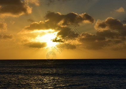 加勒比海美丽的乌云与明亮橙色天空黑暗海岸线图片