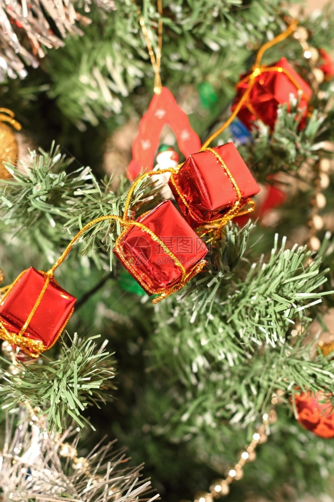 闪亮的新红色关闭圣诞节树上的红装饰在礼物形状中安装红色饰品图片