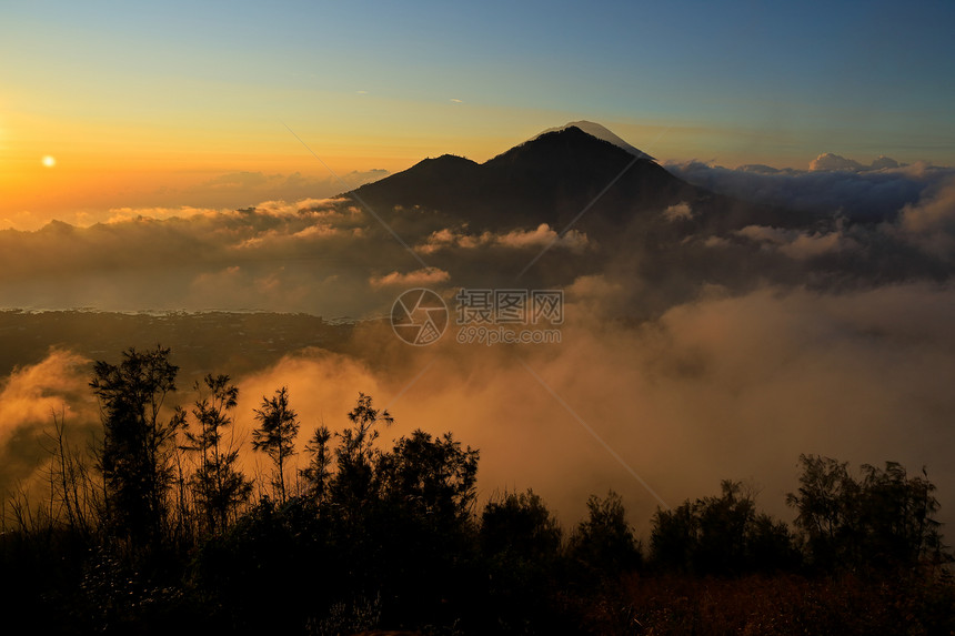 天空印度尼西亚巴厘岛BaturKintamani山火顶端日出时云雾的景象游客观图片