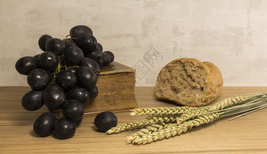 面包师宗教小麦和的冲击红葡萄和圣经作为东背景小麦面包和红葡萄木头图片