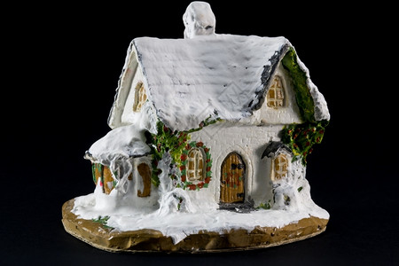 喜庆的冬天新季圣诞节装饰黑色背景上有小玩具陶瓷屋的圣诞装饰图片