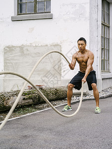 力量照片中一位亚洲肌肉男子在健身室外用训练绳子和一起锻炼身体种图片
