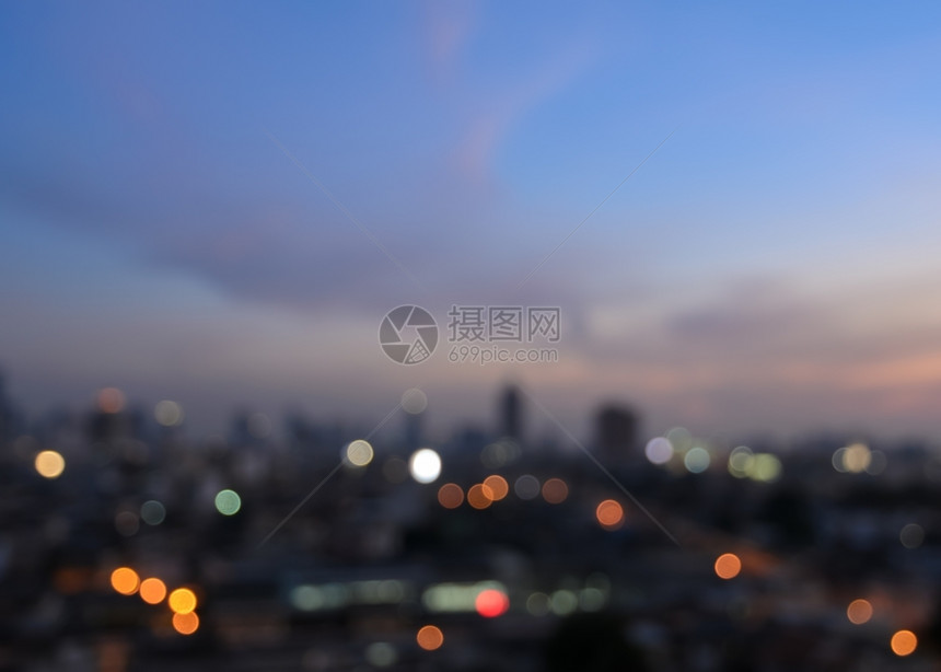 散焦闪亮的摩天大楼在黄昏时照亮城市布基灯光镇天线图片
