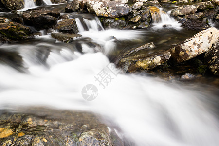 溪流河水在岩石中的快速流动沿河出行流着级联公园图片