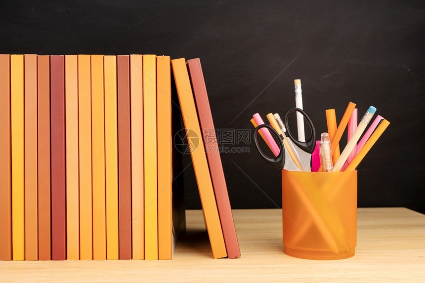 知识小样木制桌板和背景黑的书本和铅笔组架图片