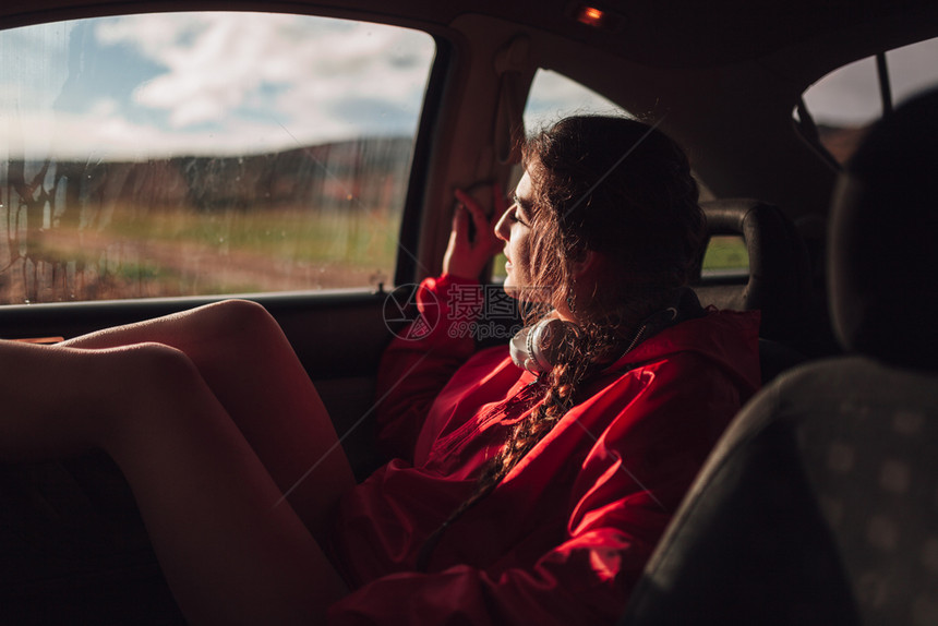 黑发座位年轻妇女在田地下雨时躲一辆汽车内避难场地图片