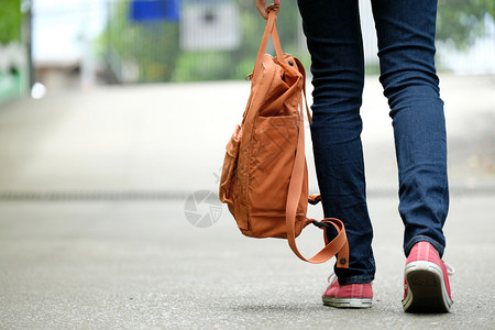 拿着书包的女学生在校园里行走图片