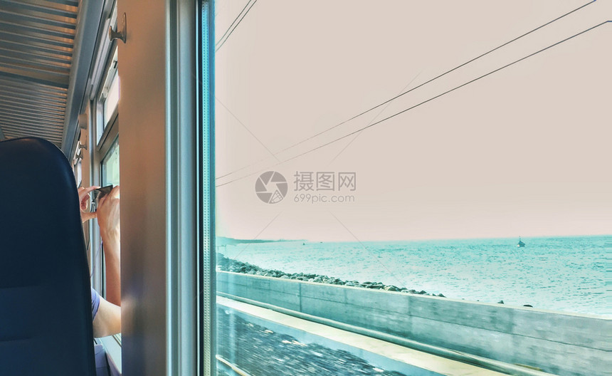 女人在火车驶近海边时从座位上拍照娱乐片内部的图片