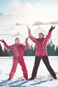 家庭父母玩亲在冬天与女儿一起户外享受雪的滋味背景图片