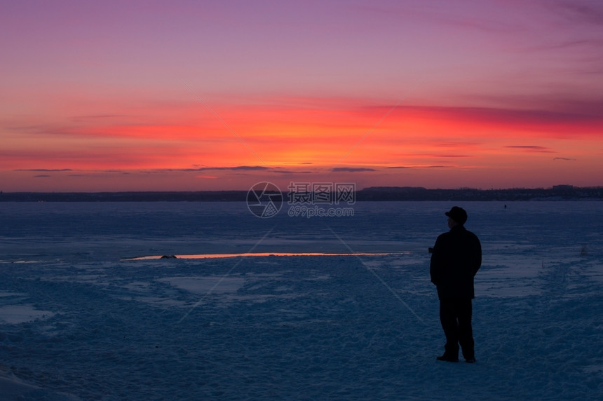 温度冷冻男人在冬季湖岸边看日落的人自然图片