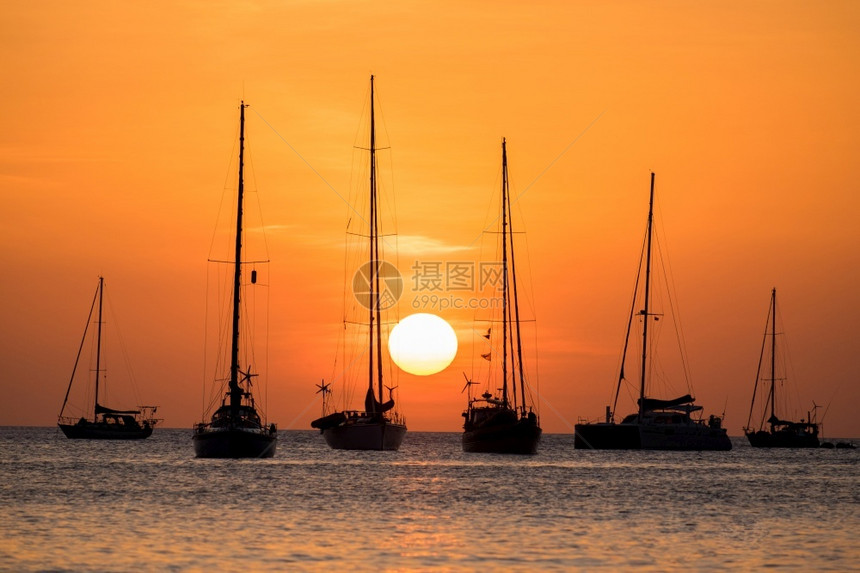 夏天海洋日落时上帆船停靠的轮椅旅游图片