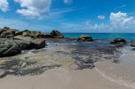 波浪反射位于蓝海边缘的大岩石圣卢西亚海滩上有苔以及印度人图片