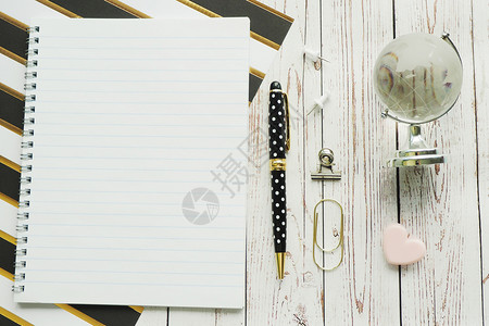 剪贴纸弹簧钢笔康乃馨剪贴和玻璃球笔记本带条纸和灰色木背景的玻璃球一种复制金子背景