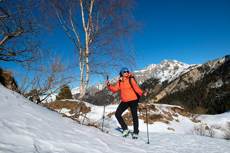 卡路里孤独徒步旅行一个女人躺着看风景在雪上山散步时看风景图片