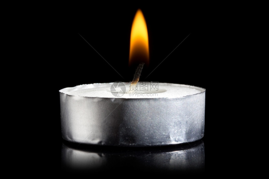 黑暗中燃烧的蜡烛小火焰辉光明亮的象征图片