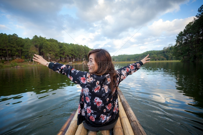 幸福年轻的女快乐年轻旅行女青举起手臂看湖边风景图片