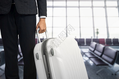商业机场出发休息室的商人和行李箱背景模糊的飞机暑假概念场候区的旅行者李箱和手提商家行李携带航班图片