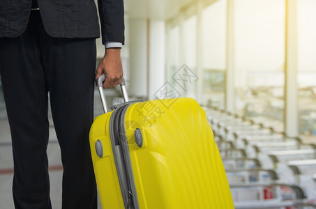 飞机场出发休息室的商人和行李箱背景模糊的飞机暑假概念场候区的旅行者李箱和手提商家行李人们护照图片