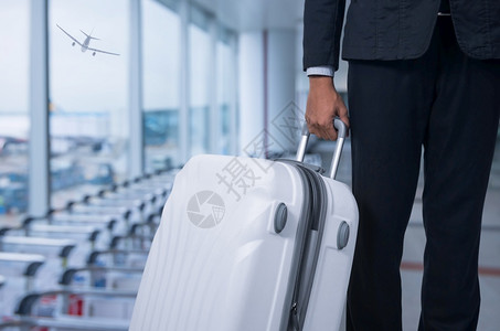 机场出发休息室的商人和行李箱背景模糊的飞机暑假概念场候区的旅行者李箱和手提商家行李游客业工作图片