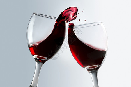 酒鬼敬两杯有溢出的红酒分享玻璃图片