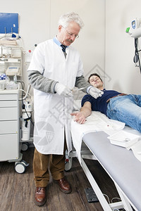 外科医生准备在紧急医疗站把一个病人的手掌上伤口缝合关心帮助剪刀图片