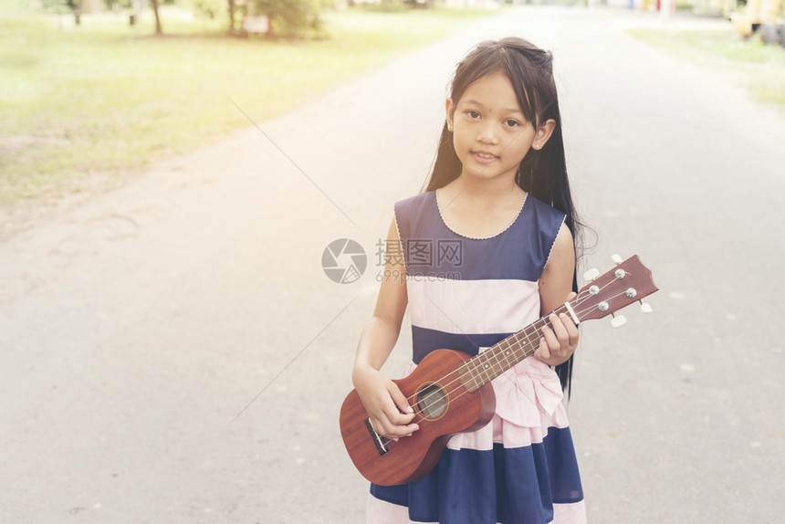 音乐家美丽的可爱小女孩弹吉他图片