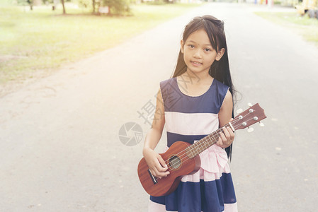 音乐家美丽的可爱小女孩弹吉他图片