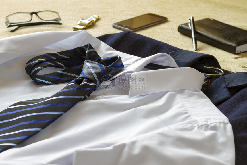 旅行随意的配件男商人服装附和床上智能手机女商人准备上办公室概念的商行人士图片
