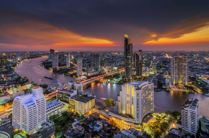商业桥酒店曼谷日落时靠近河流的现代风景建筑对河附近鸟群的现代建筑进行观察图片