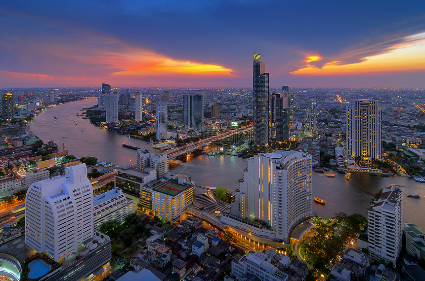 曼谷日落时靠近河流的现代风景建筑对河附近鸟群的现代建筑进行观察公寓桥晚上图片