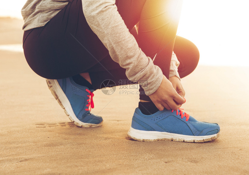 腿赛跑者女人系鞋带积极的运动图片