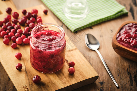 吃甜点木板上一个玻璃罐子里的cranberry果酱自然图片