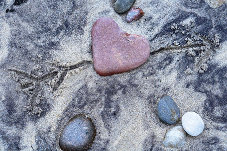 美丽的画红石心沙子上形的海石沙子上心形的海石红心抽象的图片
