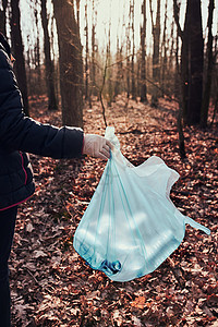 真实塑料打扫清理森林的妇女志愿者将塑料垃圾装入袋子塑料污染和过多垃圾的概念环境问题损害对的责任真实人情况在职活动家背景