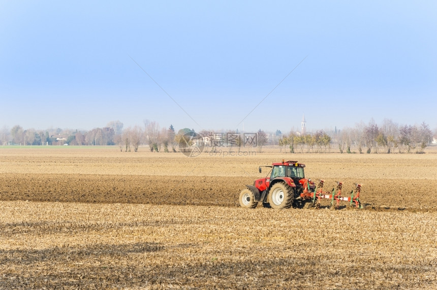 机器犁农业劳工红色拖拉机耕田犁过图片