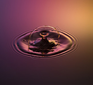 闪光灯水滴摄影一两水从高处倒入中当它们撞到水或相时被俘获闪光进入设计图片